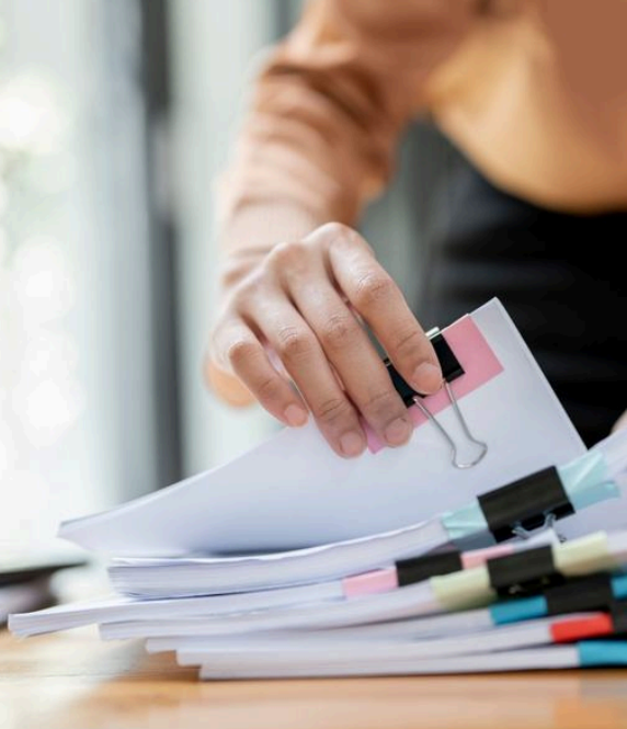Close-up of legal paperwork being sorted, illustrating the detailed administrative work involved in estate planning and business law.